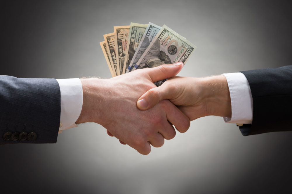 dollar-bills-between-two-shaking-hands-Knowledge-Webcasts