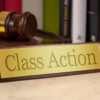 Golden sign with engraved word class action - class action on a desk with gavel