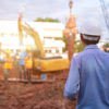 Engineer technician watching team of workers at construction site, Engineer technician Looking Up and Analyzing an Unfinished new construction Project.